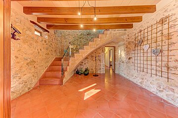 A stone wall with a staircase leading up to the second floor