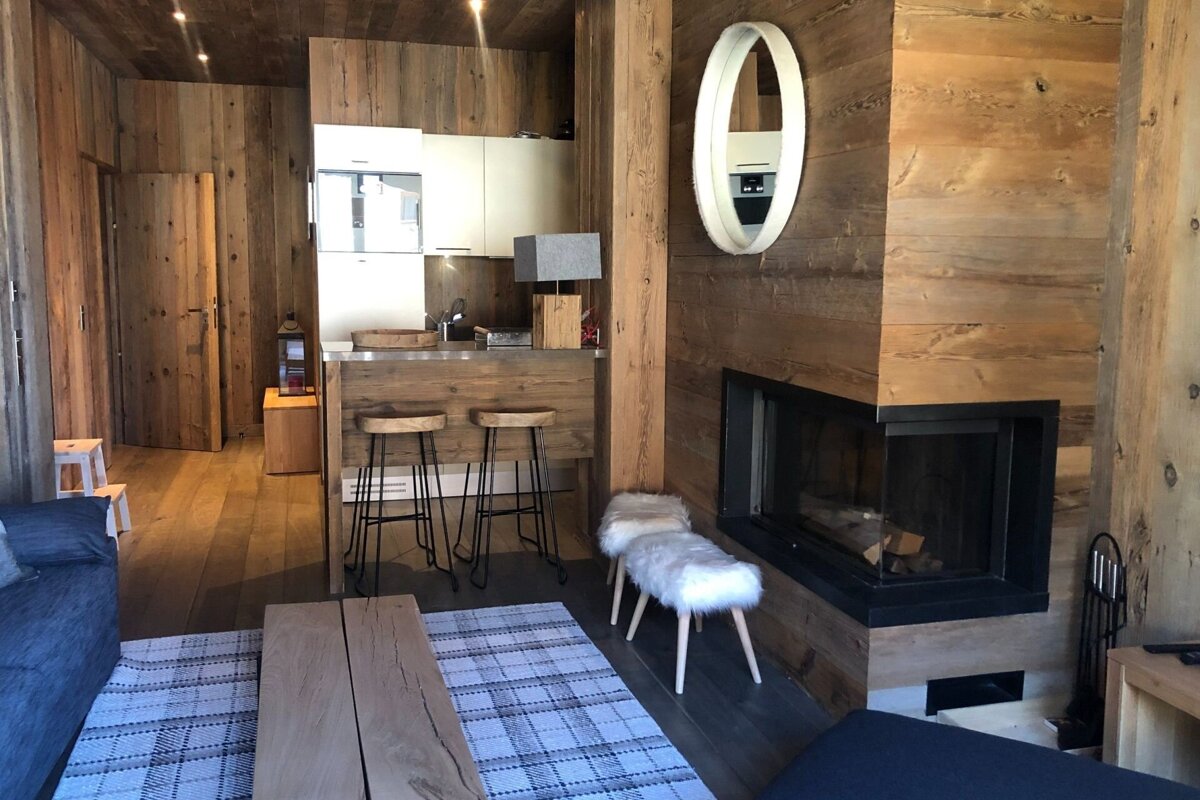 A living room with a fireplace and a mirror on the wall