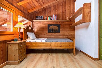 A bedroom with a wooden bed and a painting of a bear on the wall