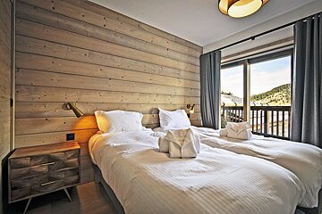 A bedroom with two beds and a sliding glass door