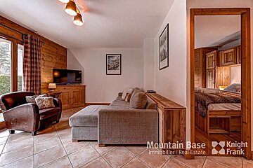 A living room with a couch a chair and a television from mountain base knight frank
