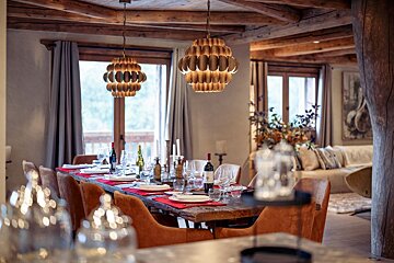 A dining room with a wooden table and chairs