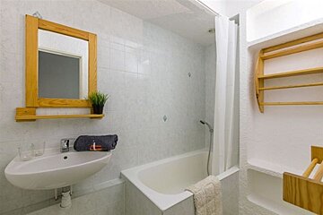 A bathroom with a sink a bathtub and a mirror