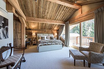 A bedroom with a king size bed and chairs