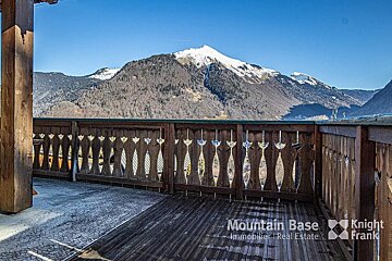 A balcony with a view of mountains and the words mountain base knight frank