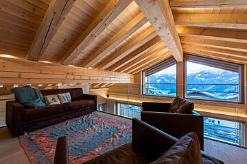 A living room with a couch and chairs and a view of the mountains