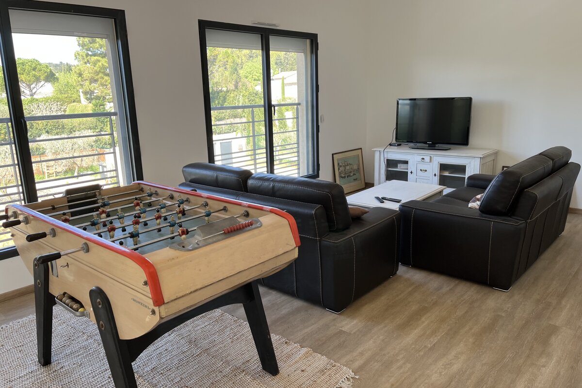 A living room with a foosball table and a flat screen tv