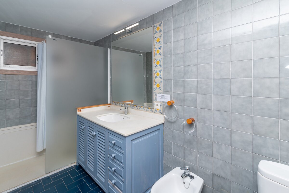 A bathroom with blue cabinets and a toilet