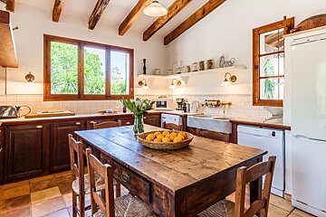 A kitchen with a wooden table and chairs and a white refrigerator