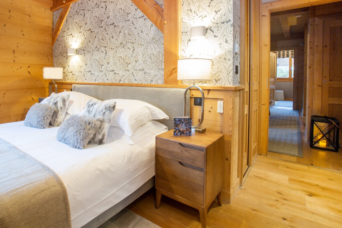 A bedroom with a large bed and a nightstand