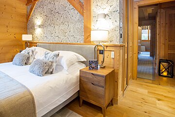 A bedroom with a large bed and a nightstand