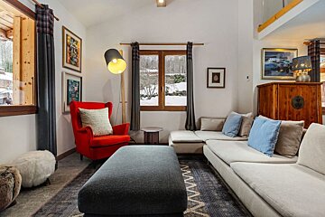 A living room with a couch and a red chair