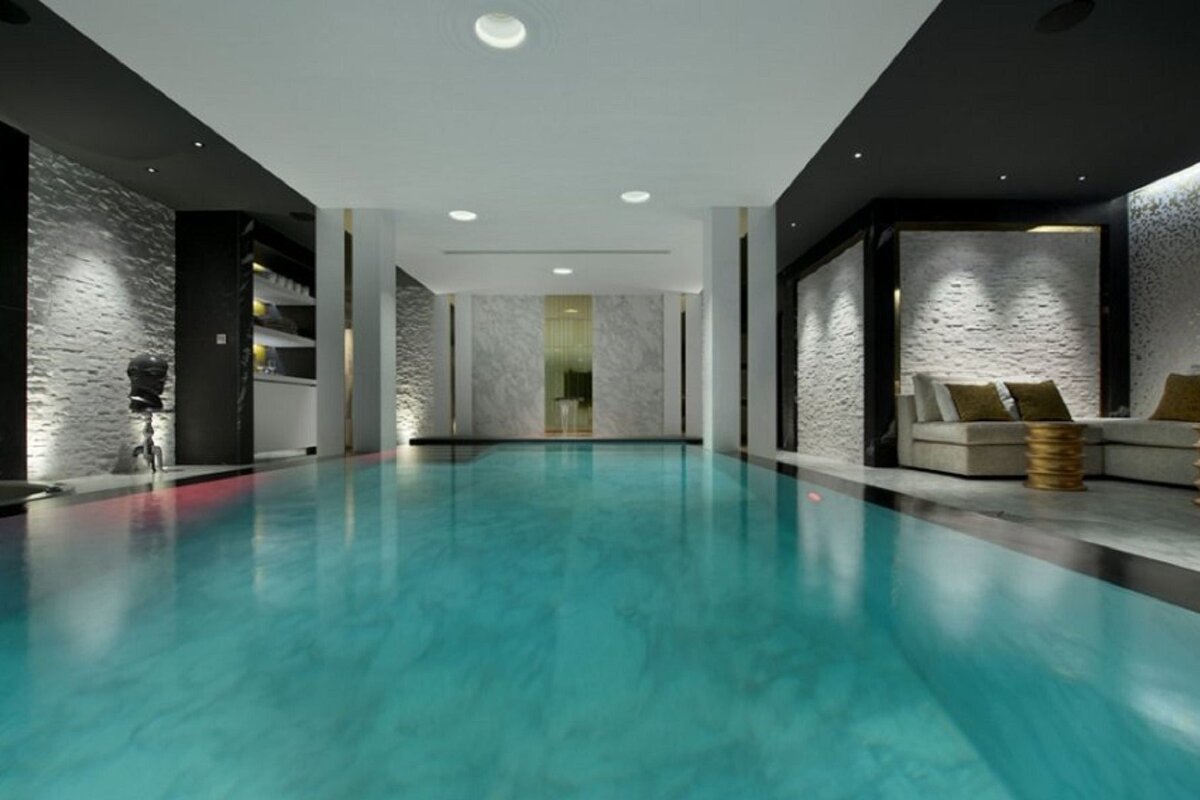 A large indoor swimming pool with a bar in the background