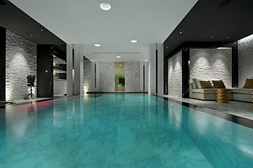 A large indoor swimming pool with a bar in the background