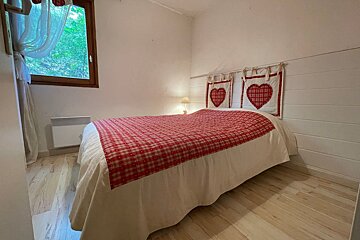 A bedroom with a bed and hearts on the headboard