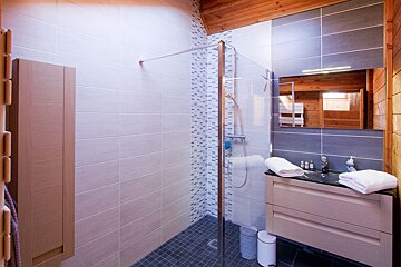A bathroom with a walk in shower and a sink