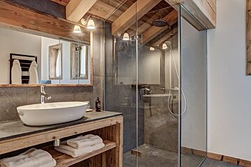 A bathroom with a sink and a walk in shower