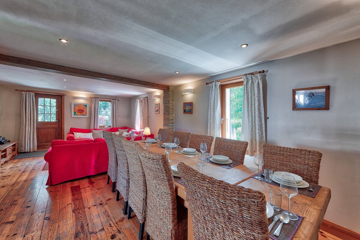 A dining room with wicker chairs and plates on the table