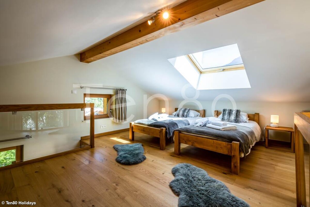 A bedroom with two beds and a skylight taken by ten80 holidays