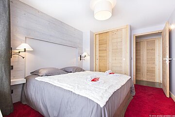 A bedroom with a large bed and a wooden door