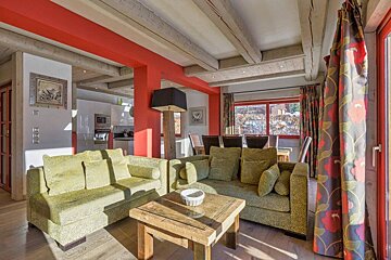 A living room with a green couch and a wooden table