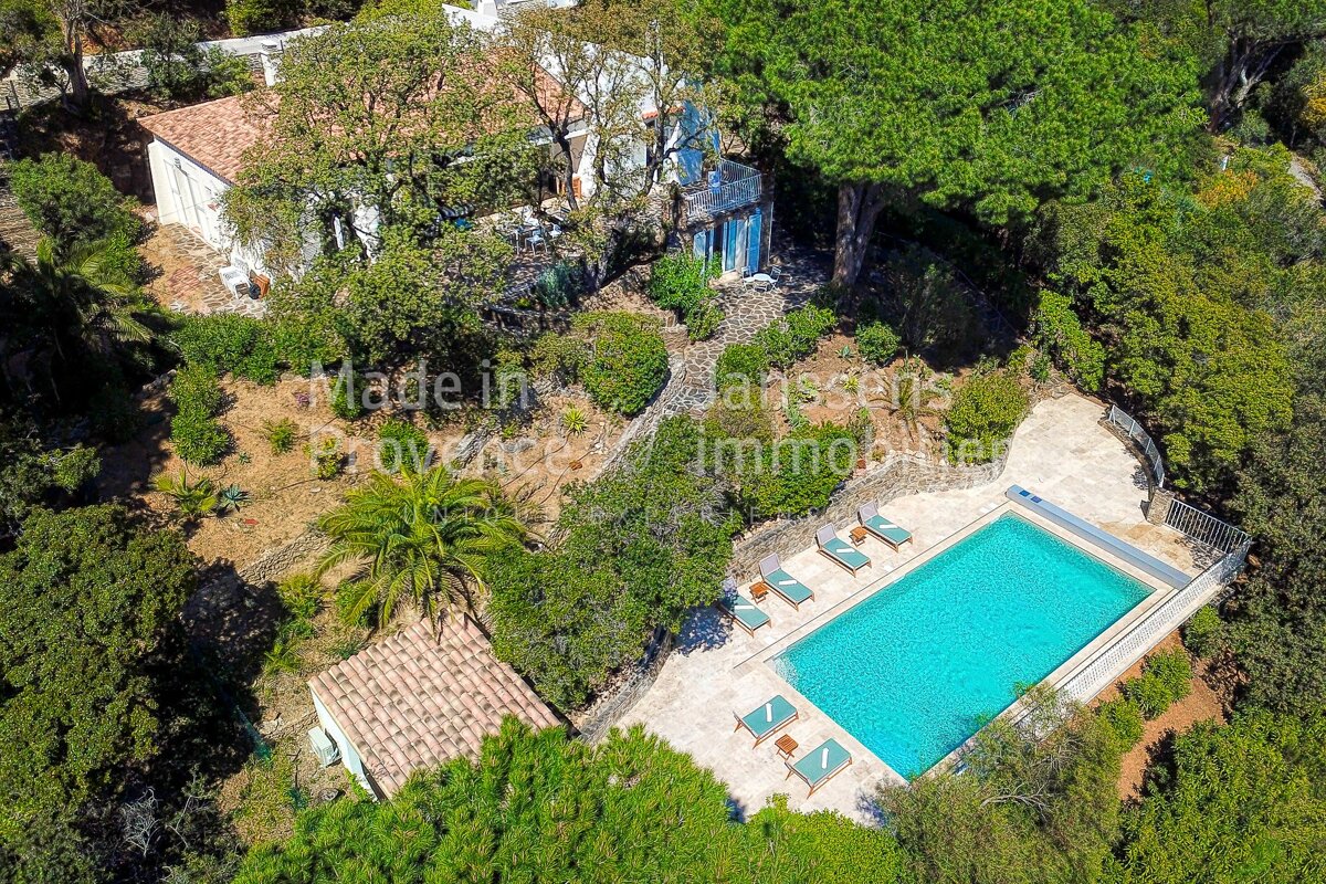 An aerial view of a house with a large swimming pool
