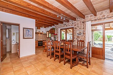 A dining room with a wooden table and chairs