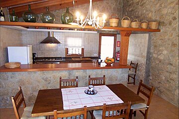 A kitchen with a table and chairs and a fire extinguisher