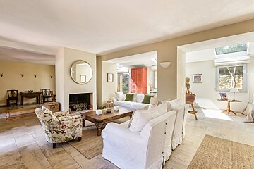 A living room with white furniture and a fireplace