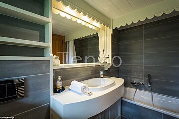 A bathroom with a sink and a bathtub and the word tengo on the wall