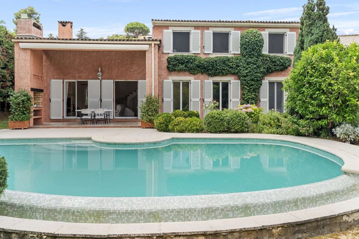 A large house with a swimming pool in front of it