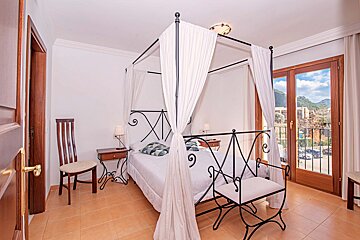 A bedroom with a canopy bed and a chair