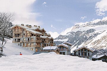A snowy mountain with a large building in the foreground