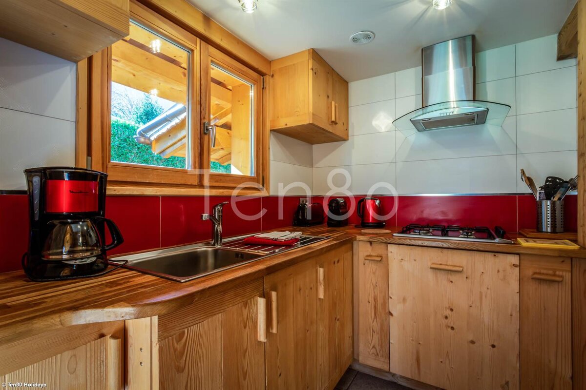 A kitchen with wooden cabinets and a coffee maker that says ten80
