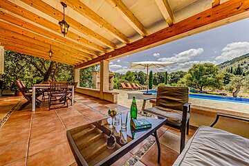 A table with a book on it sits on a patio overlooking a pool