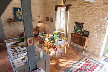 A dining room with a table and chairs and a rug