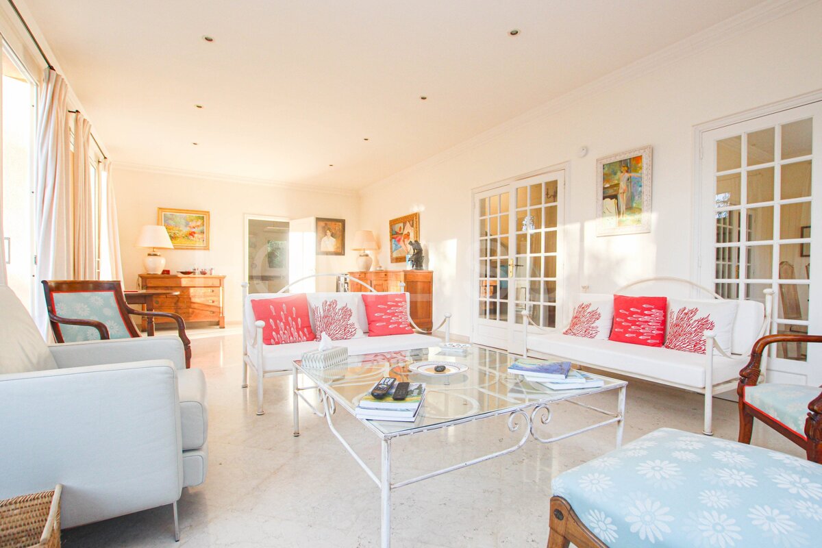A living room with white furniture and a glass coffee table
