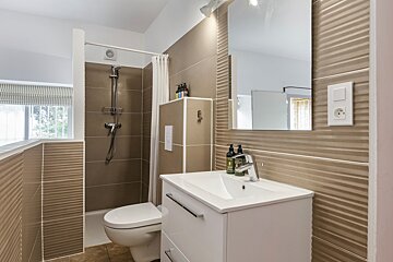 A bathroom with a toilet a sink and a mirror