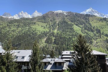 A view of a mountain range with a few buildings in the foreground