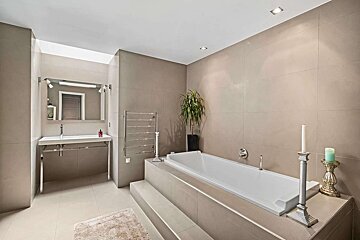 A bathroom with a large bathtub and a sink