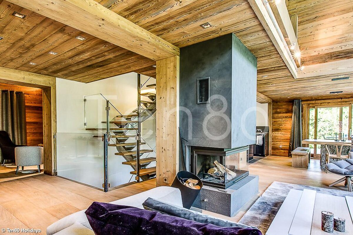A living room with a fireplace and a staircase with the number 180 on the wall