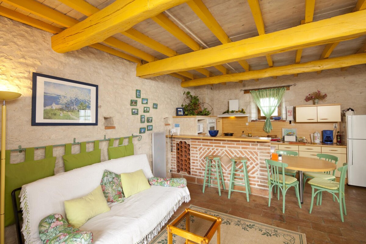 A living room with a white couch and green pillows