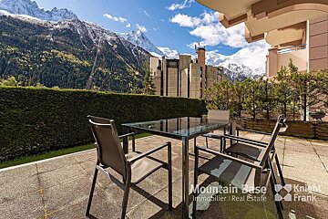 A patio with a table and chairs and the words mountain base on the bottom
