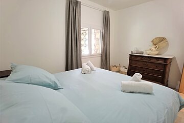 A bedroom with a dresser and a bed with blue sheets