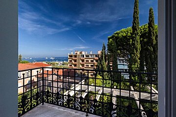 A balcony with a view of a city and the ocean