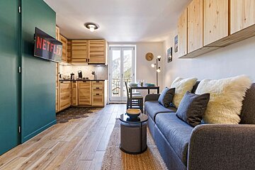A living room with a couch and a flat screen tv that says netflix