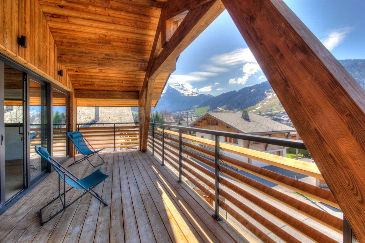 A balcony with chairs and a view of the mountains