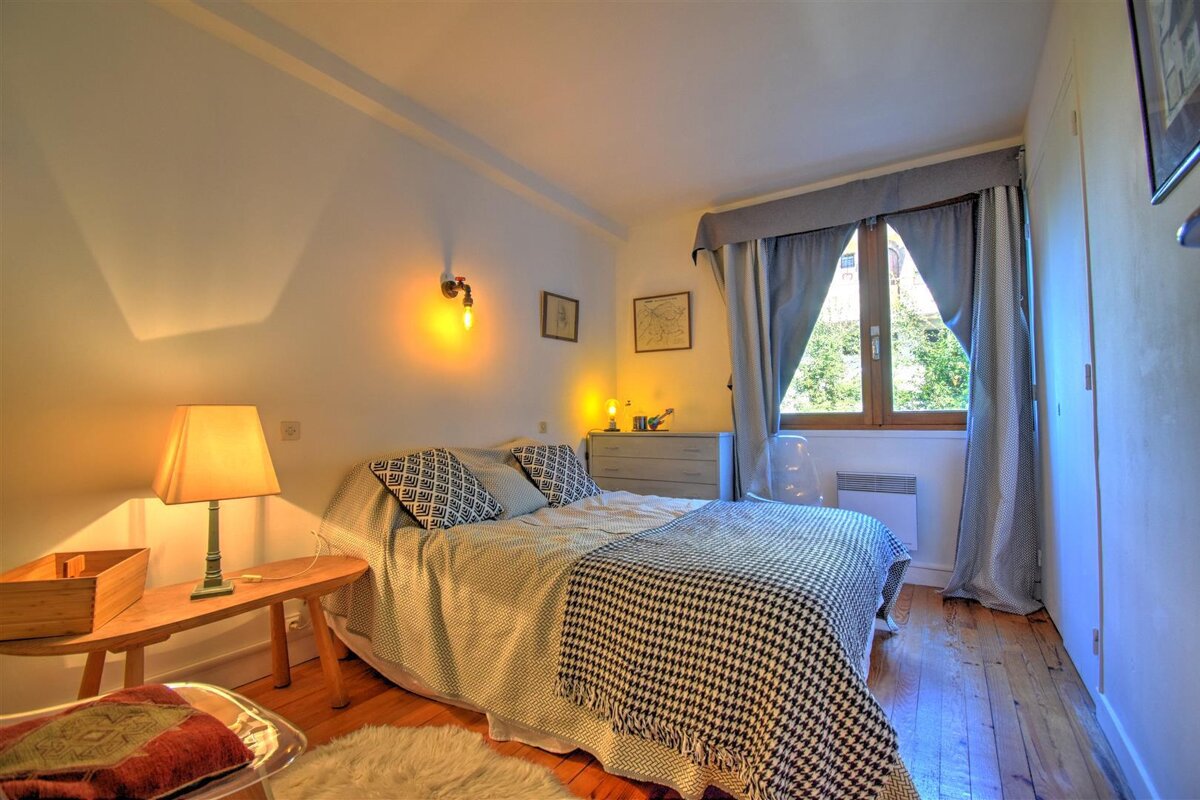 A small bedroom with a bed and a lamp