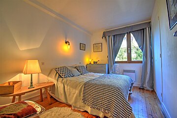 A small bedroom with a bed and a lamp