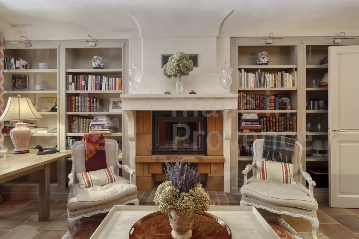 A living room with two chairs and a fireplace with a sign that says provence